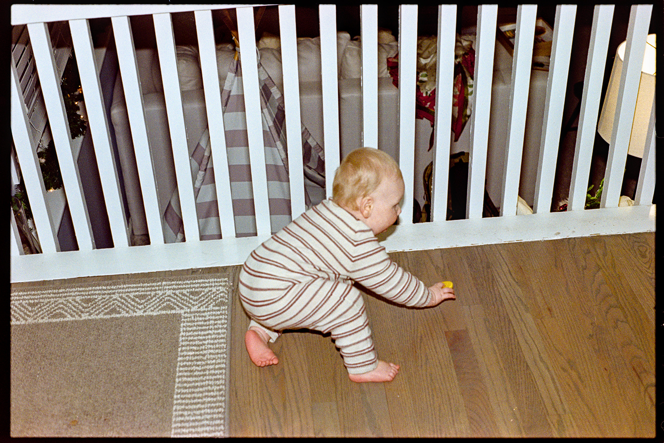 Young child crawling on the floor of a house