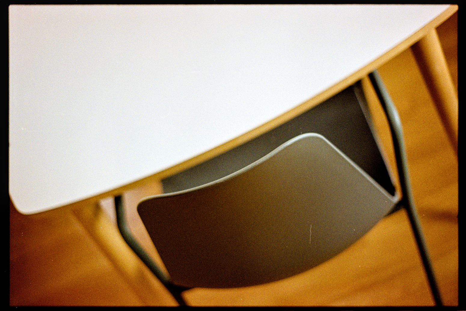 Green chair at a white table taken from an angle