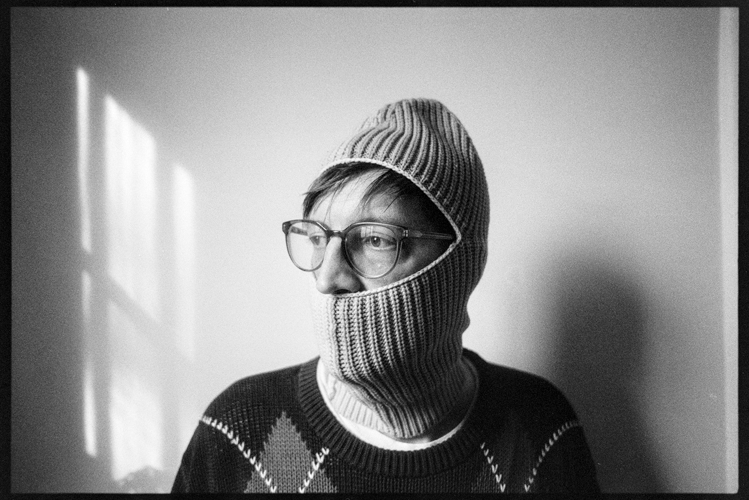 Jason in a ski mask looking to the side toward the window