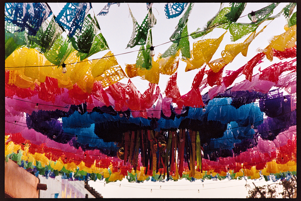 Bright multicolored decorative flags above an intersection in Oaxaca