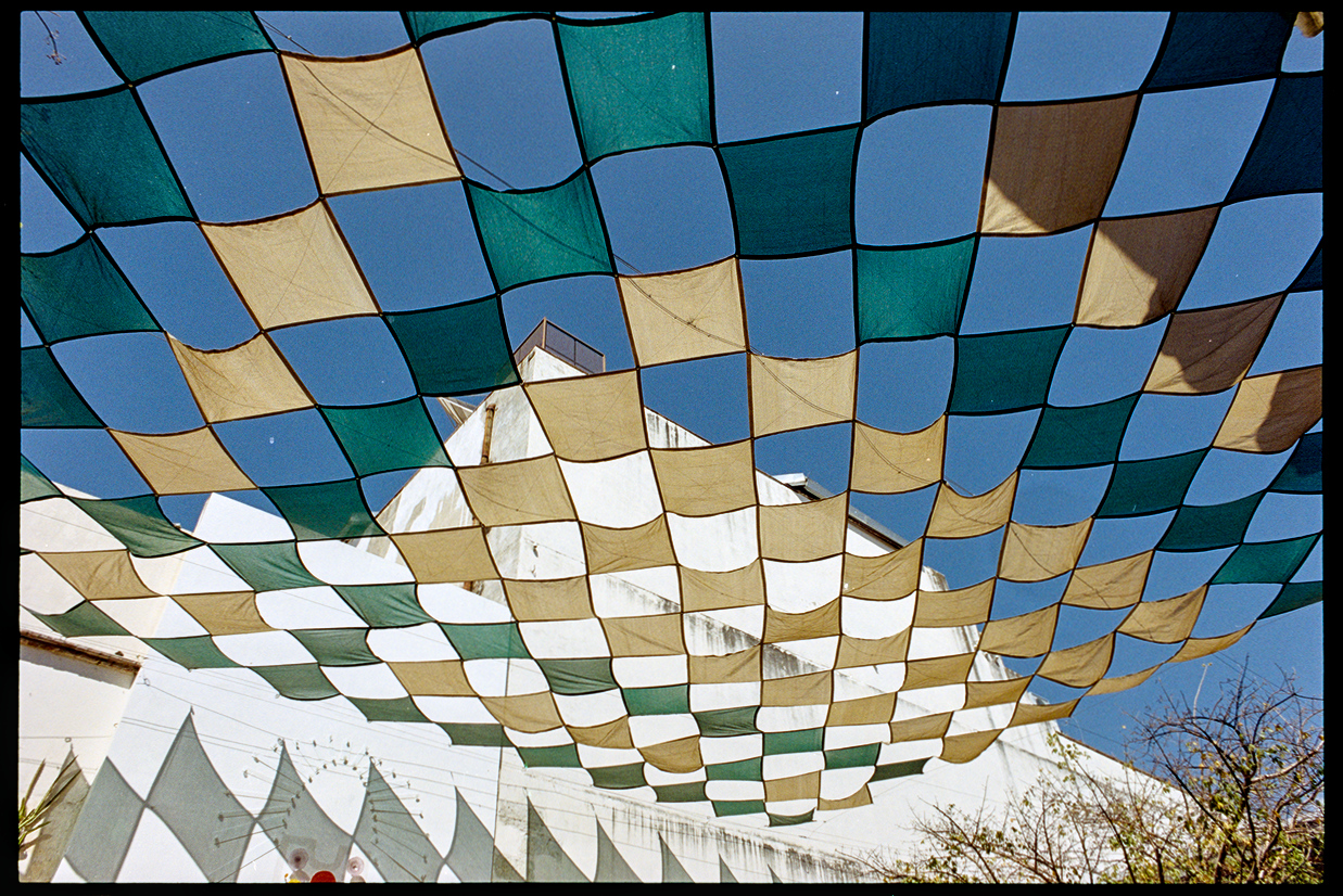 A checkered grid flags hung above a courtyard in Oaxaca