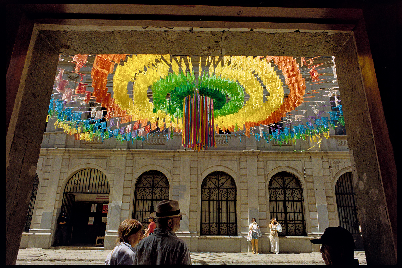 Street with bright colorful flags above it in Oaxaca City