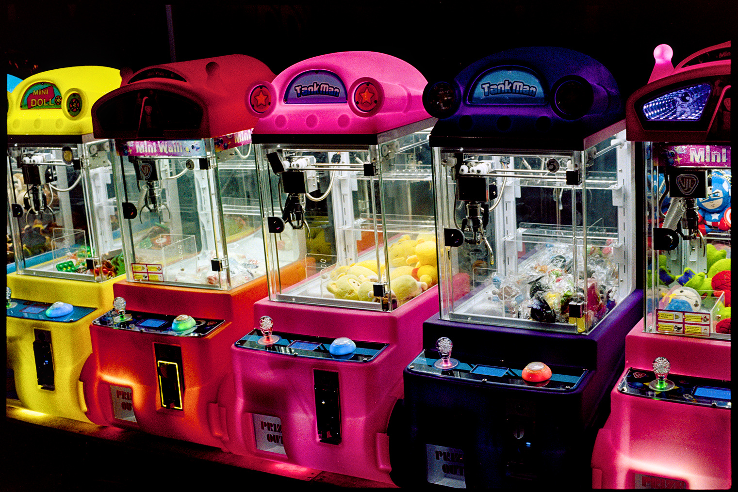 Neon claw machines in a park at night in Oaxaca City