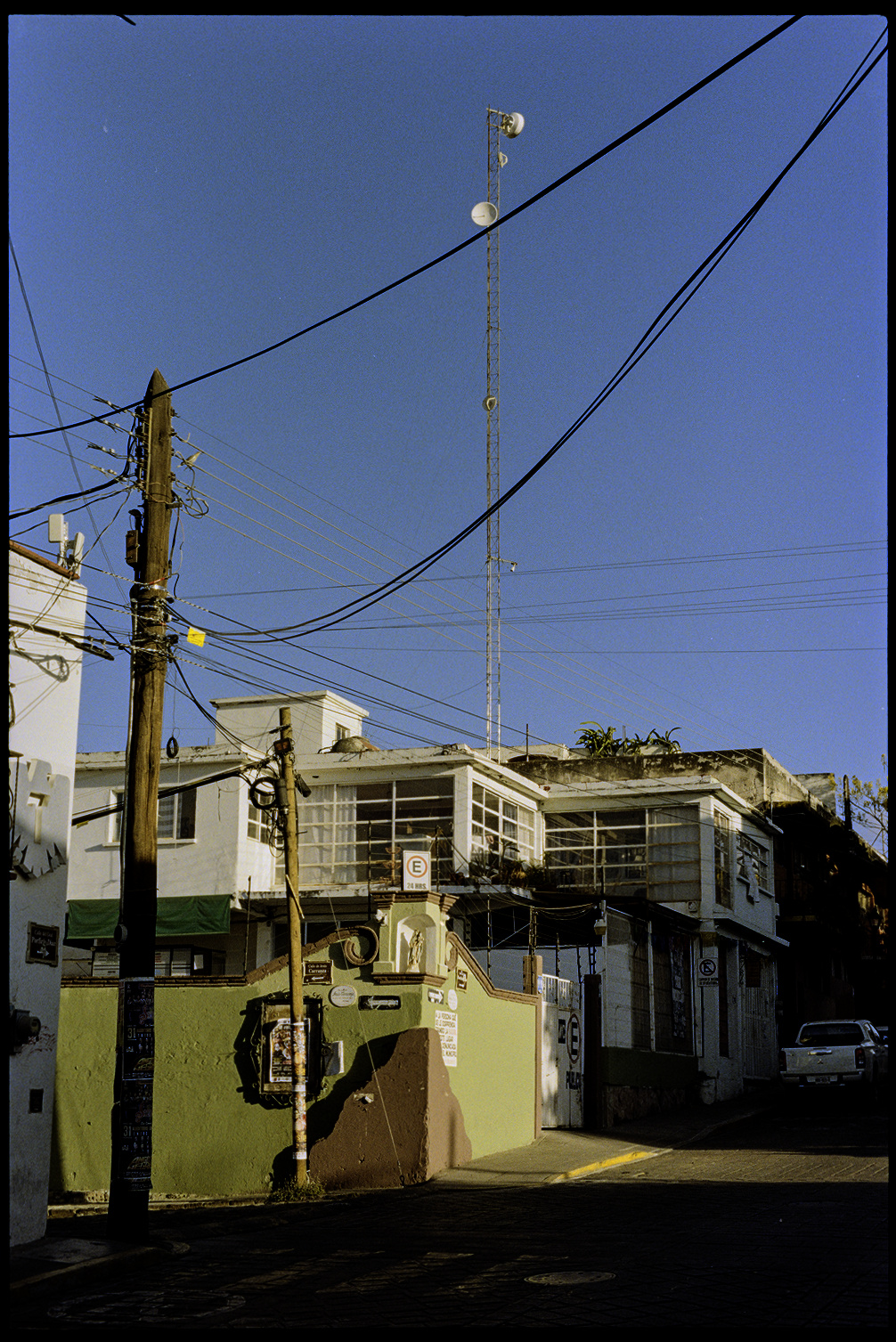 Intersection with telephone pole, cell phone tower, and wires in Oaxaca City