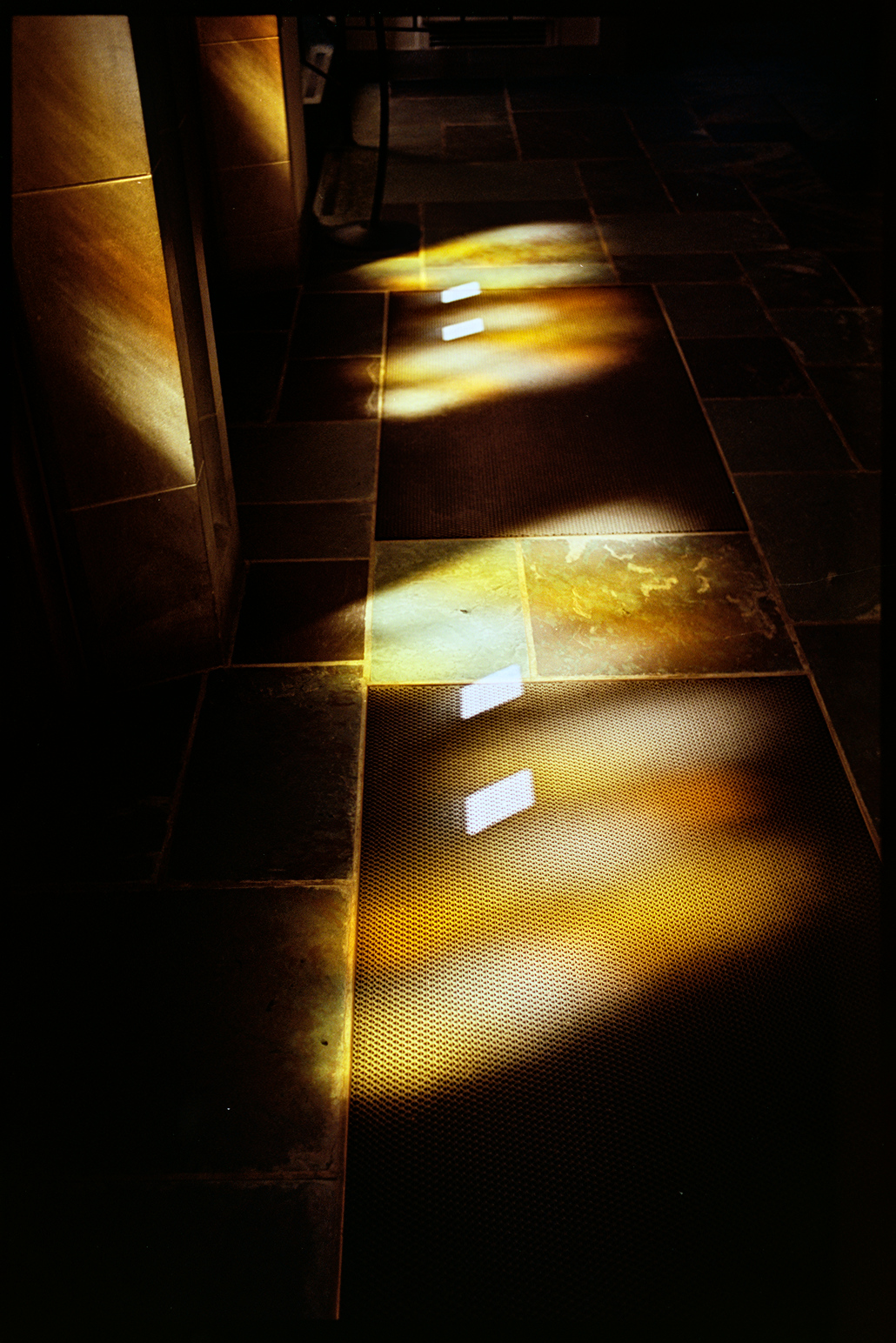 Sun coming through stained glass doors falling on the floor in the chapel