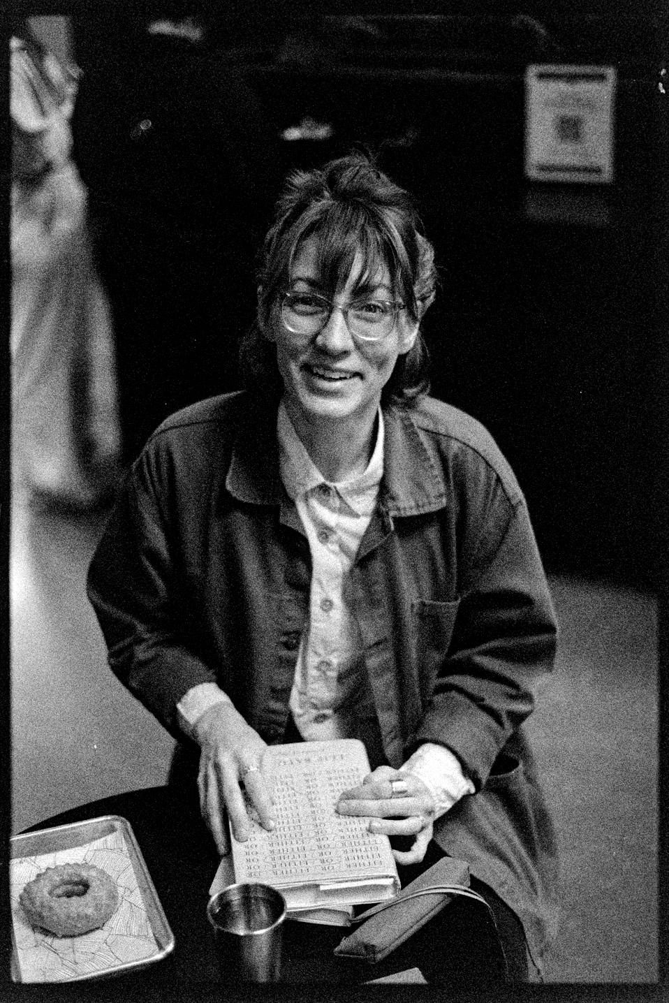 Kallie at the Tala Coffee Shop sitting at a table with her book and donut