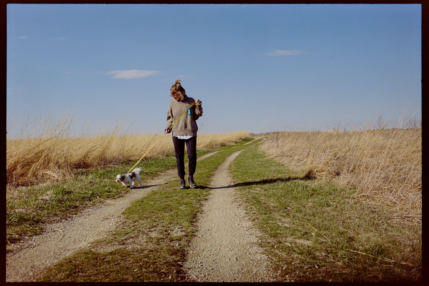 Kallie walkoing Annie the dog through the prairie