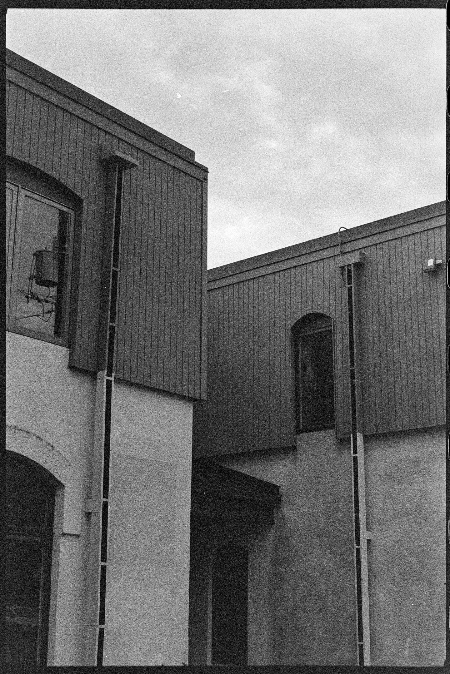 Corner of a building with cloudy sky above