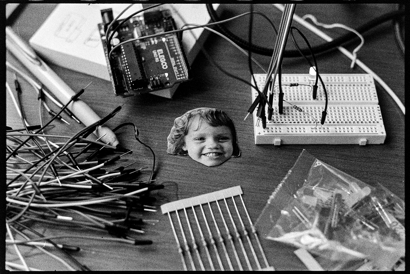 Desktop with electronic circuits and small photo of Suvi
