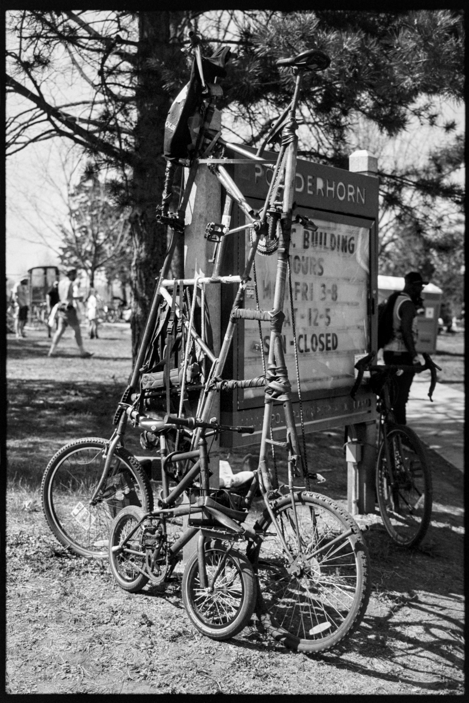 Tall bike leaned against the Powderhorn Park sign at Mayday festival