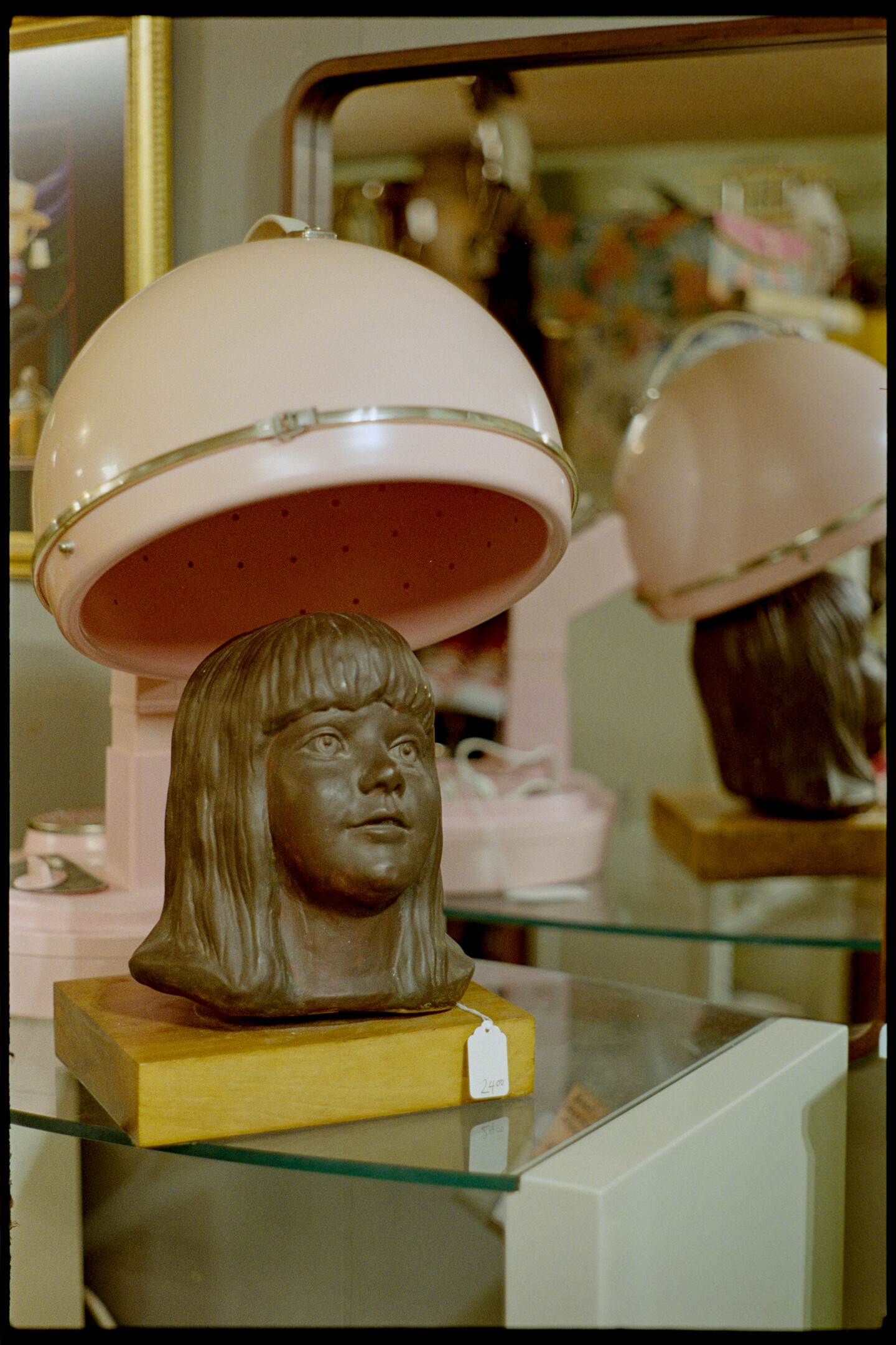 Bronze head under an old pink salon hair drier