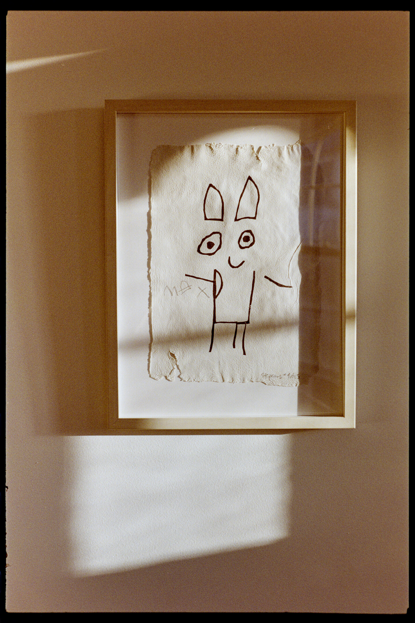 A crude print of a smiling cartoon character hanging on our wall