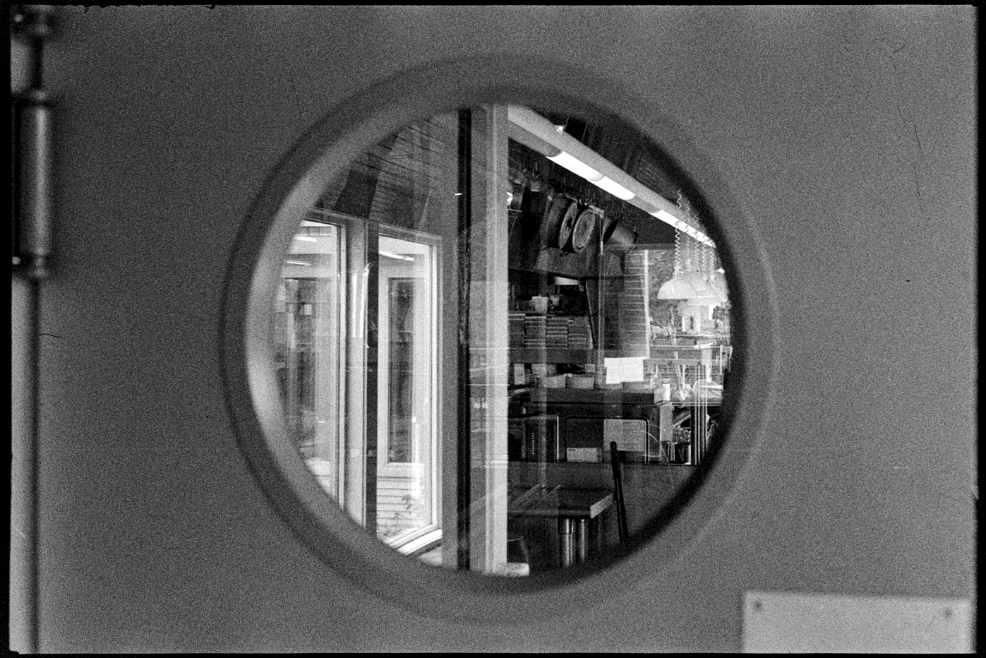 View through a porthole of a restaurant kitchen