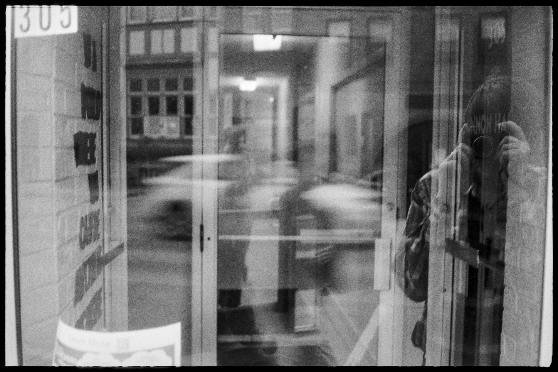 Jason in the reflection of glass doors on the main street