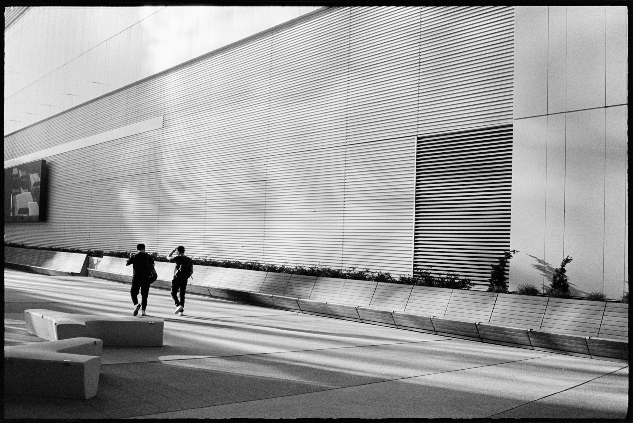 Two men walking between buildings in the evening sun in Midtown Atlanta