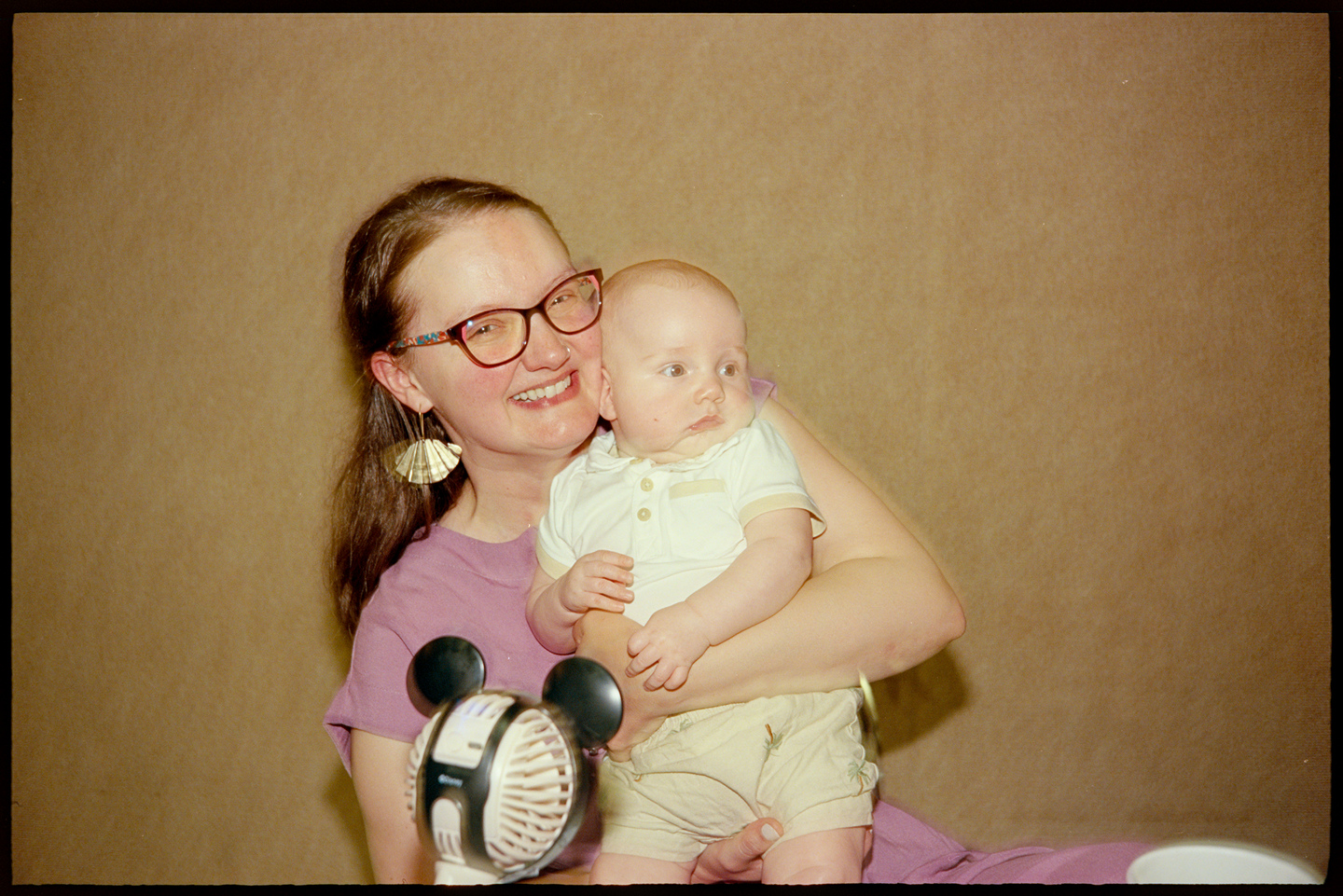 Courtney holding her infant son Huey at a wedding reception