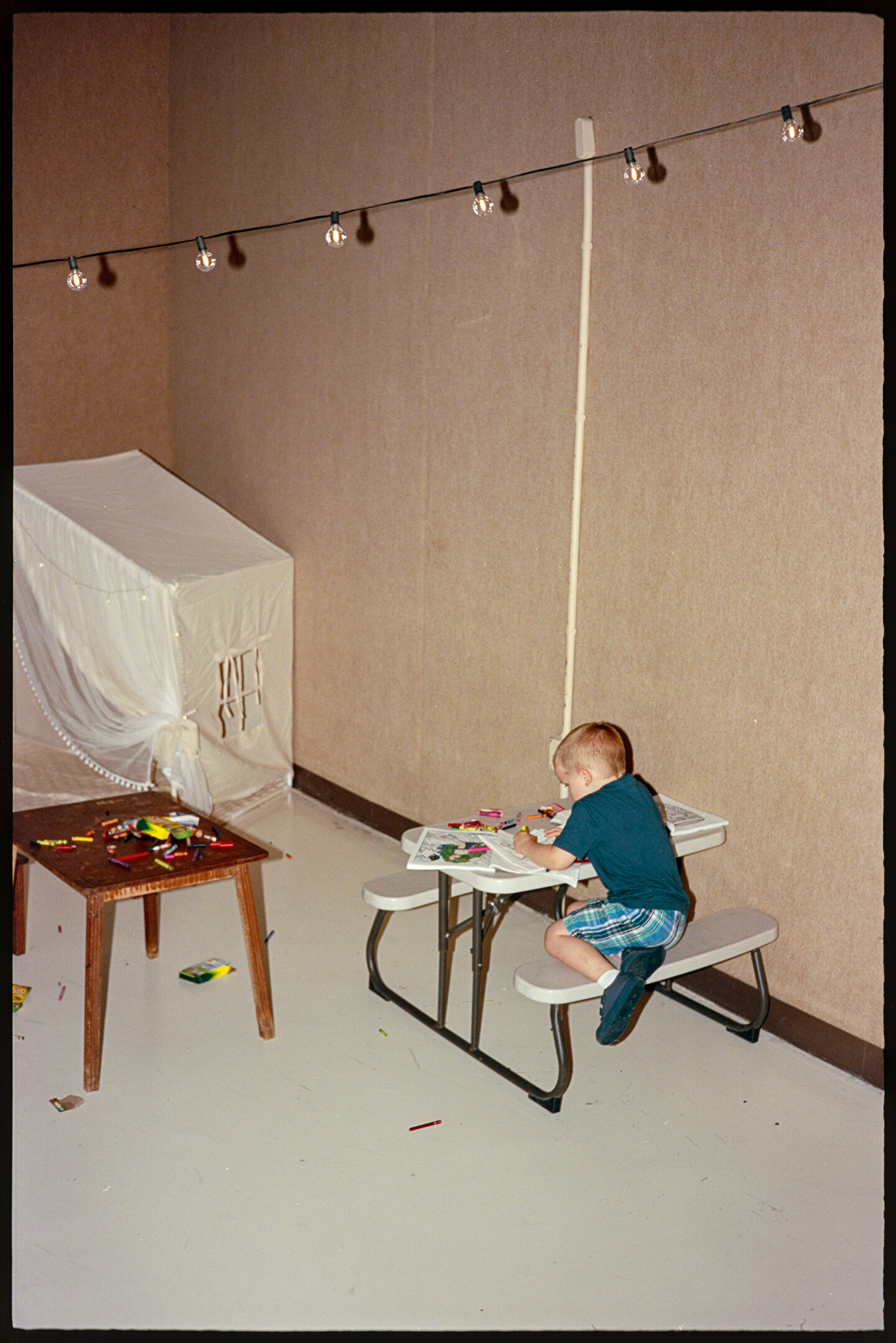 A boy coloring at a table at a wedding reception