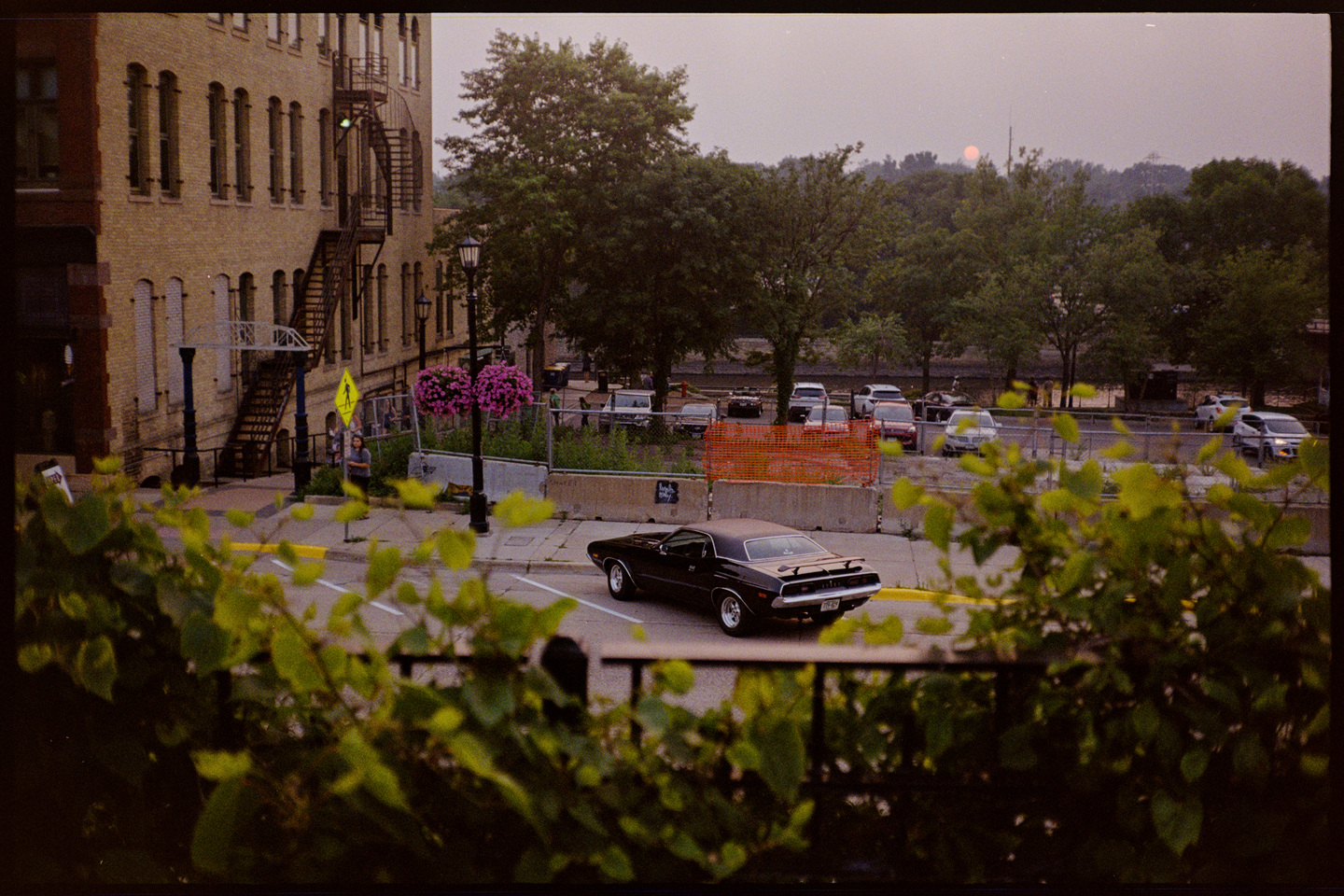 Division Street in the twilight with a red setting sun, a vintage black hotrod parked on the street