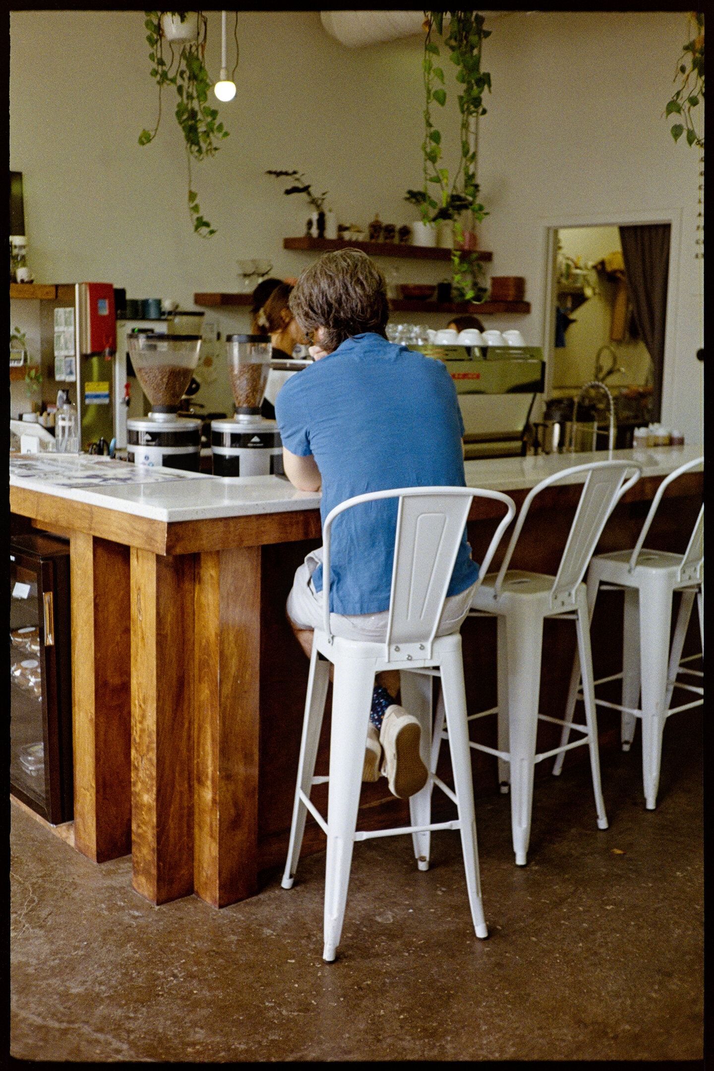 A man sitting at the espresso bar of Horizon Line coffee shop in Des Moines