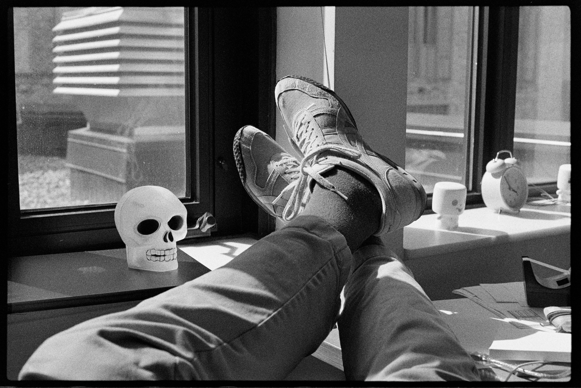 Jason's feet up on his desk with plastic skull beside them
