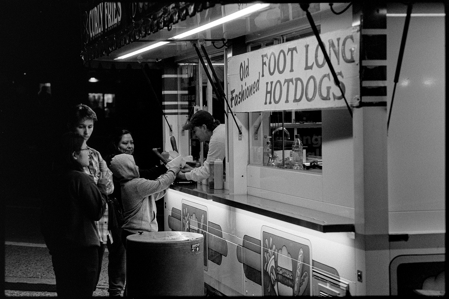 People in line for corn dogs at the fair at night