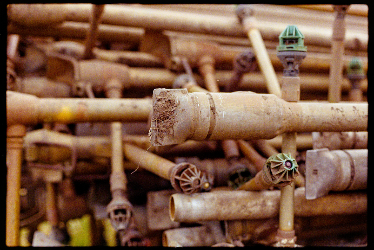 A pile of red brown pipes in a farm field