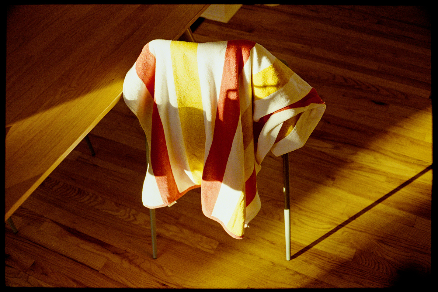 Beach towel draped over a chair in the sunlight