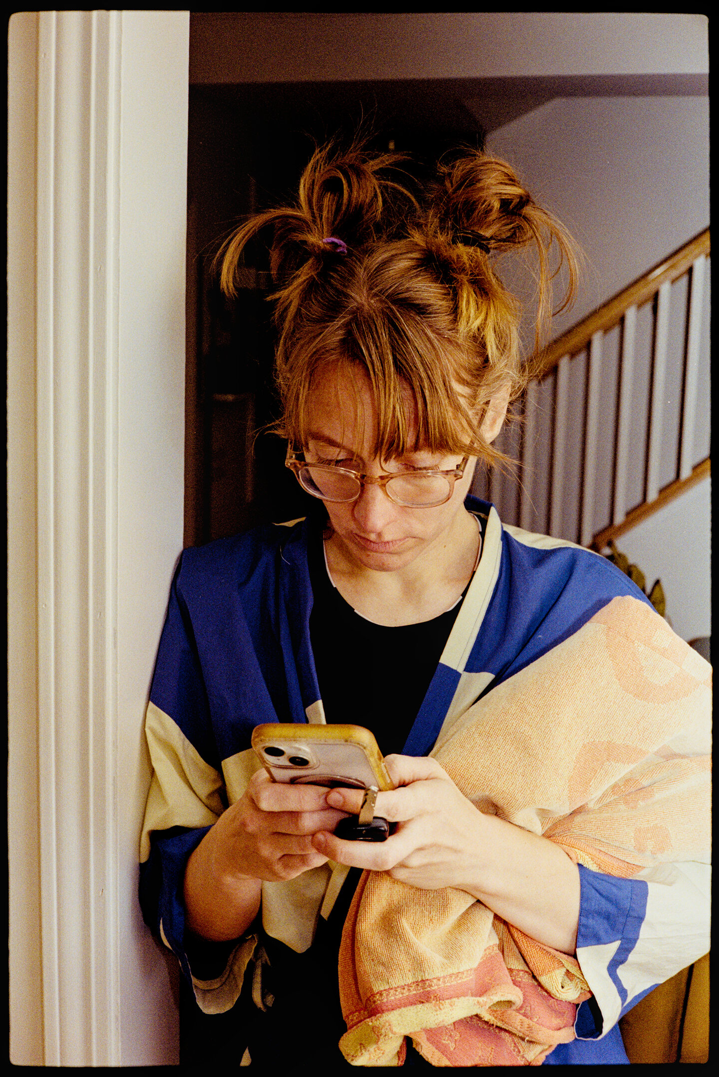 Kallie looking at her phone in the kitchen