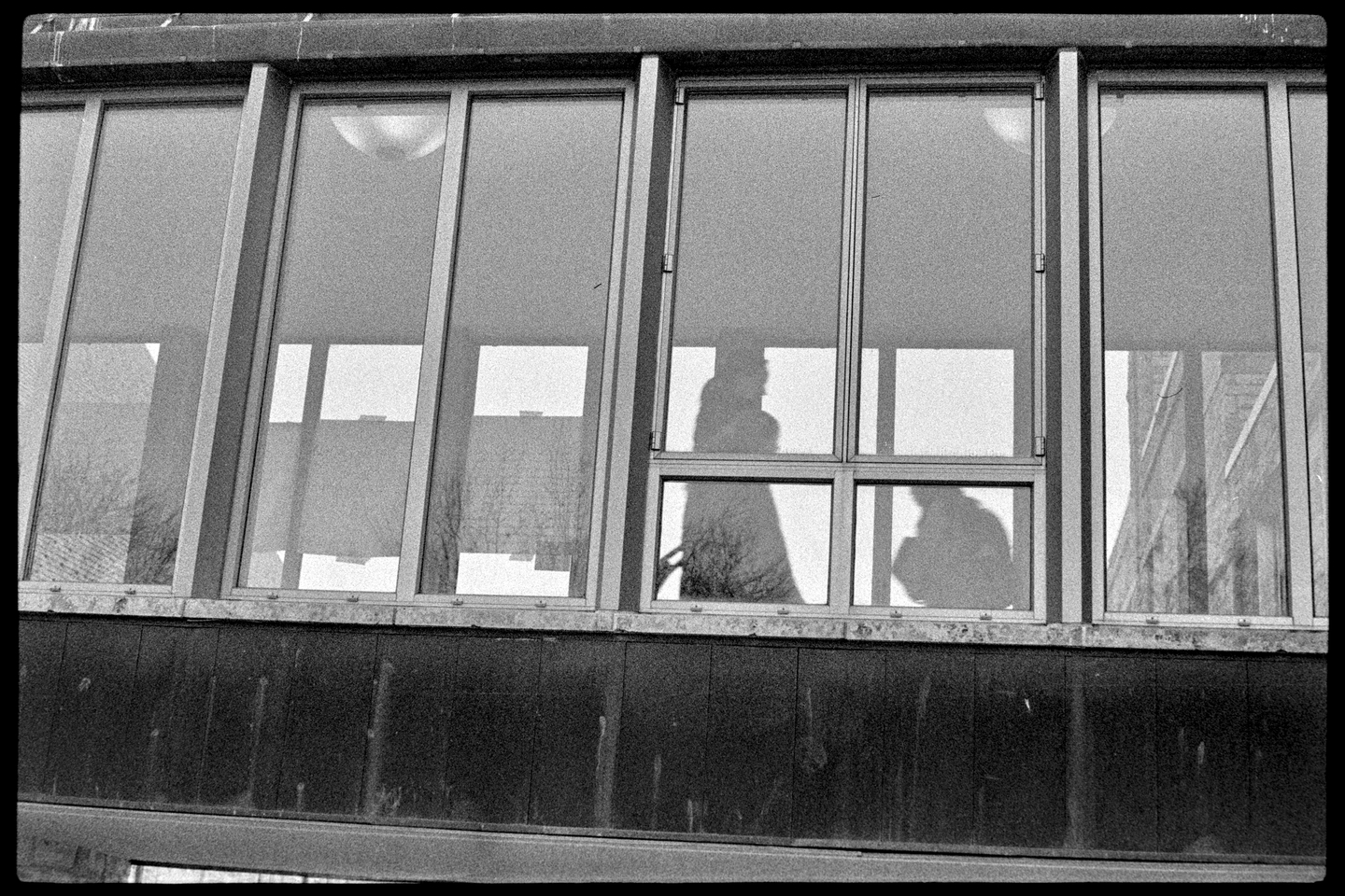 People in shadows walking through corridor between two buildings at St. Olaf College