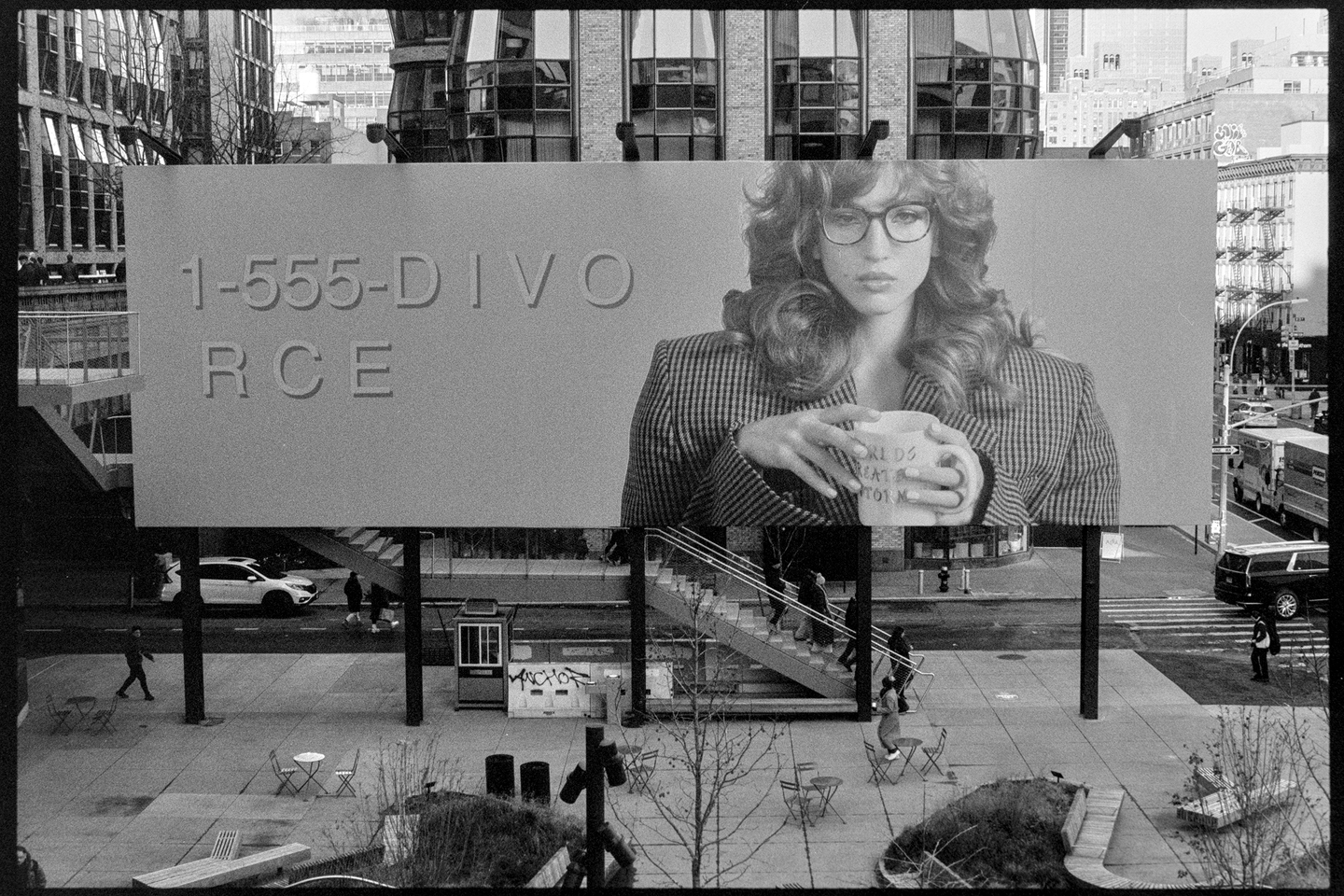 A billboard in Chelsea that says 1-555-DIVORCE with a woman holding a mug