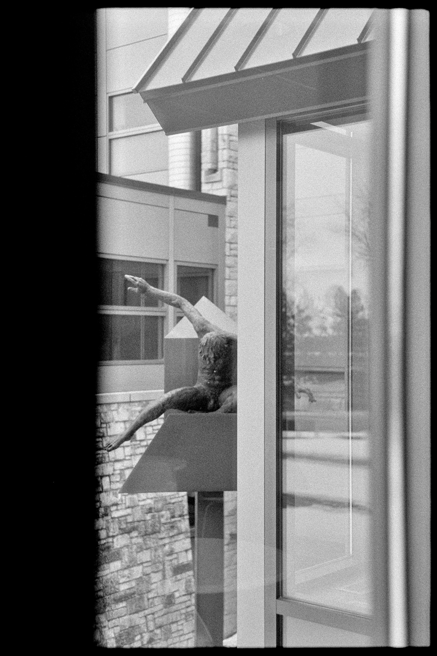 A metal statue of a man behind the St. Olaf College art building