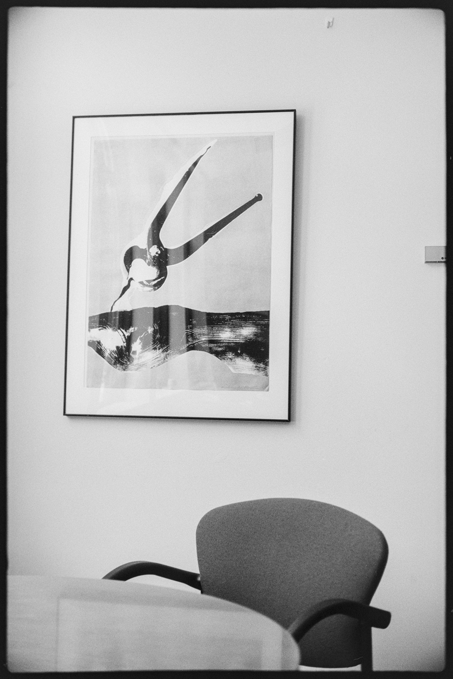 My office at the library with a framed print on the wall and a chair at a round table