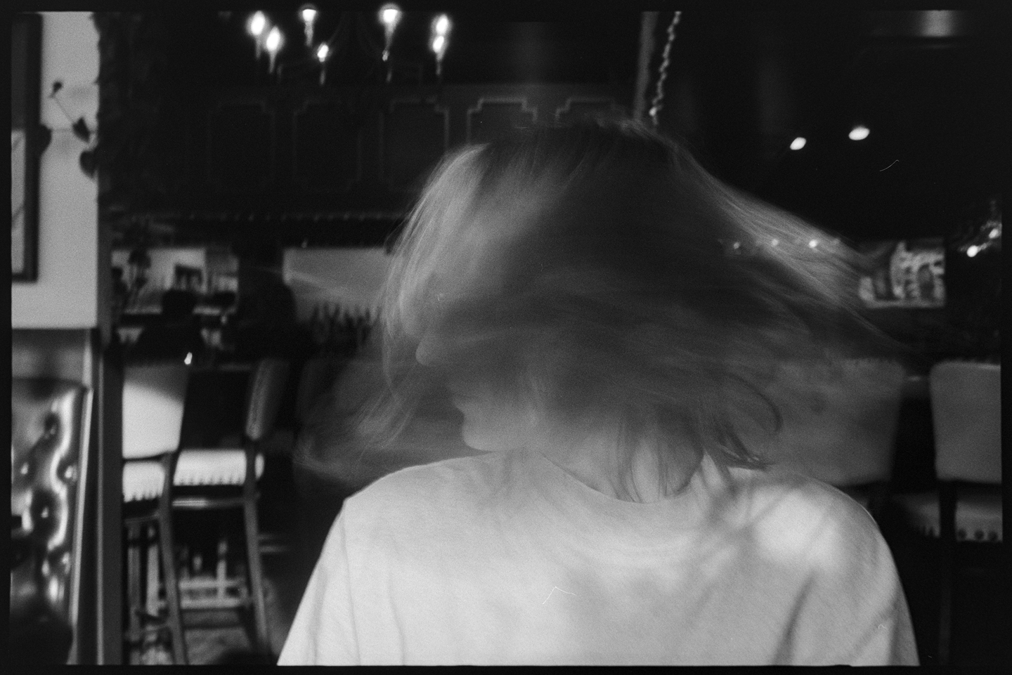 Kallie in a restaurant shaking her head to make a blurry motion effect in the photo