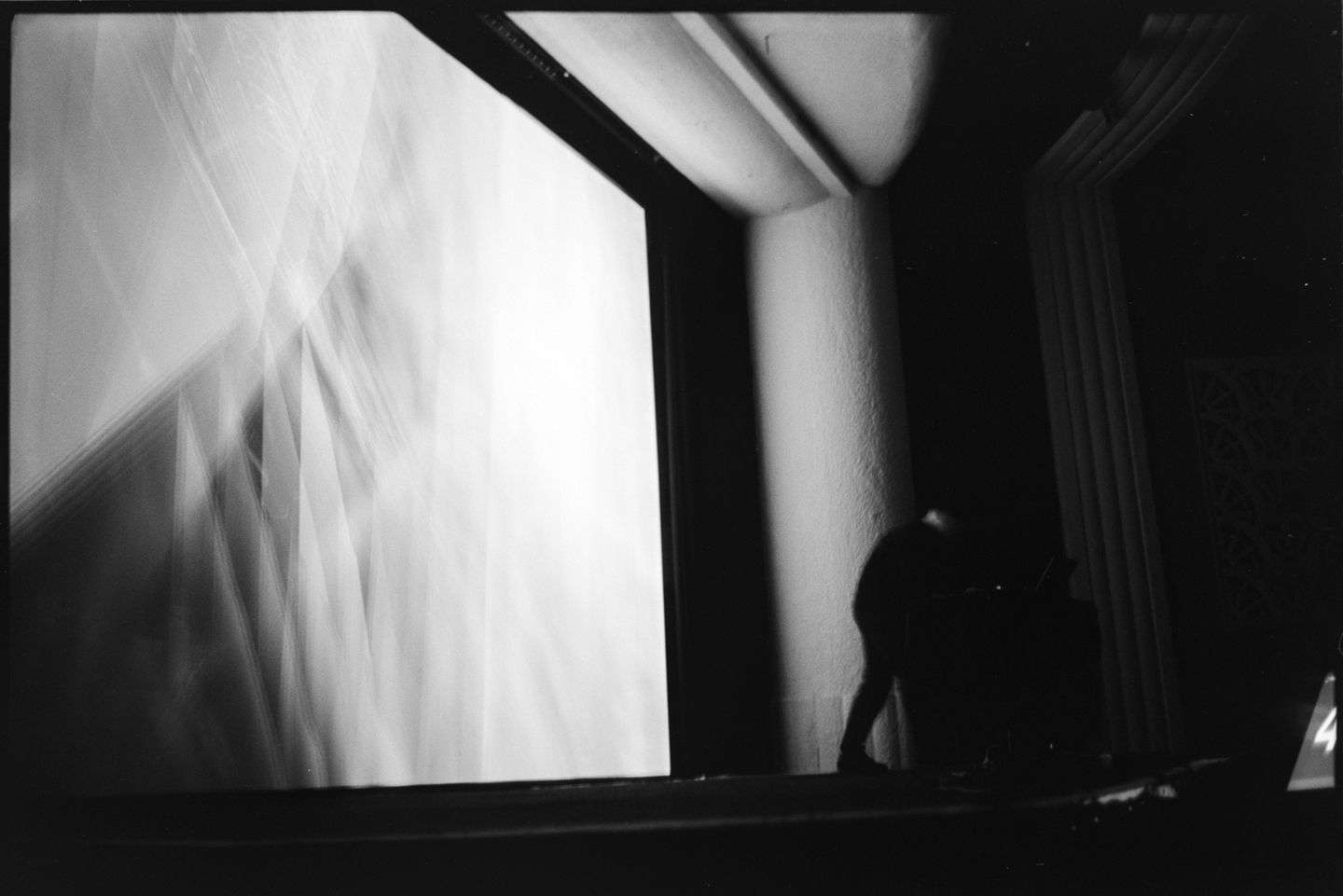 Tom Hall performing on a laptop in front of a large projection of digital animation at the Algorithmic Art Assembly v.3