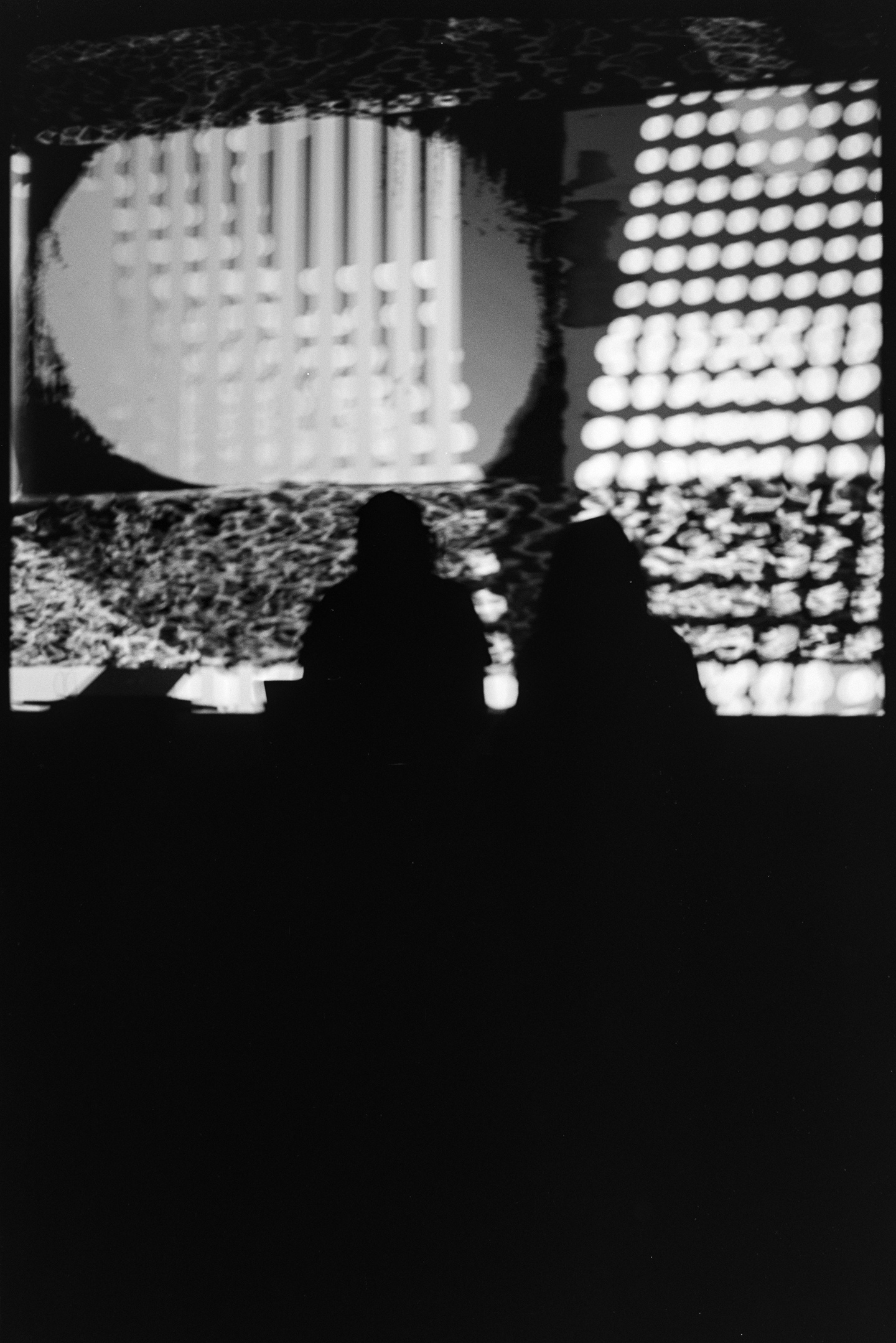 The musical duo of Codie in front of a large projection of digital animation at the Algorithmic Art Assembly v.3