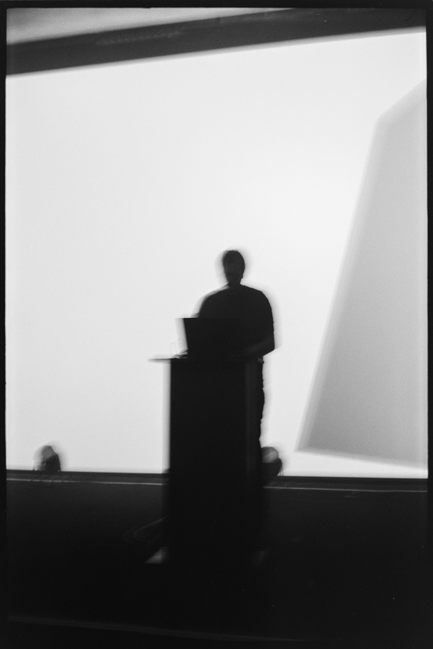 Gabor Lazar in front of a large projection of digital animation at the Algorithmic Art Assembly v.3