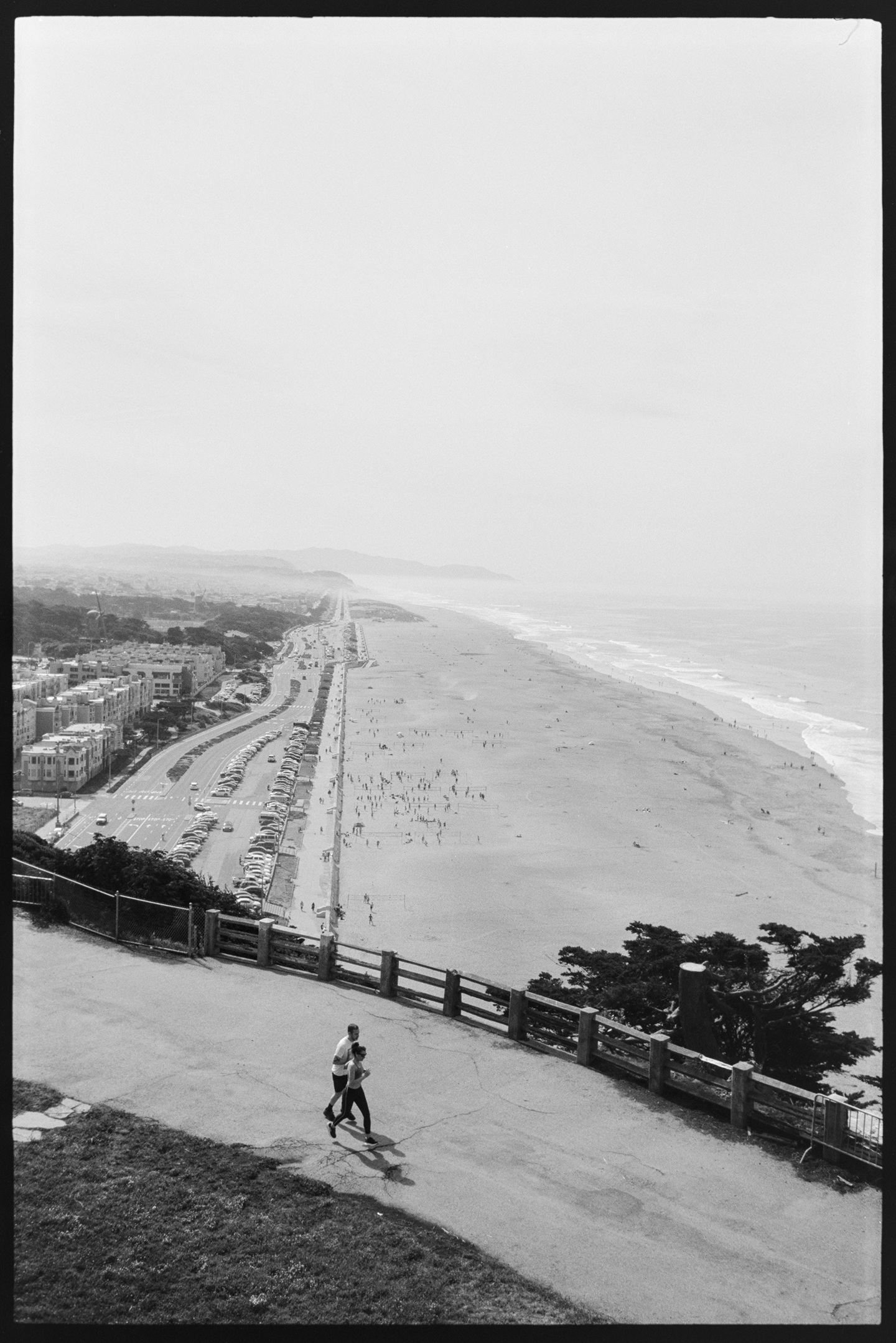 Two people jogging on a path overlooking the Pacific coast at Sutro Heights in San Francisco