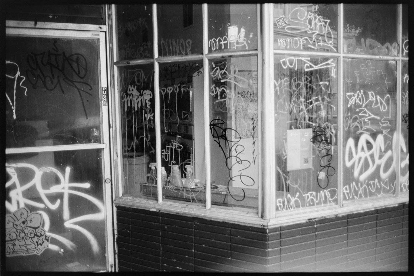 The graffiti-covered storefront of an abandoned laundromat in San Francisco