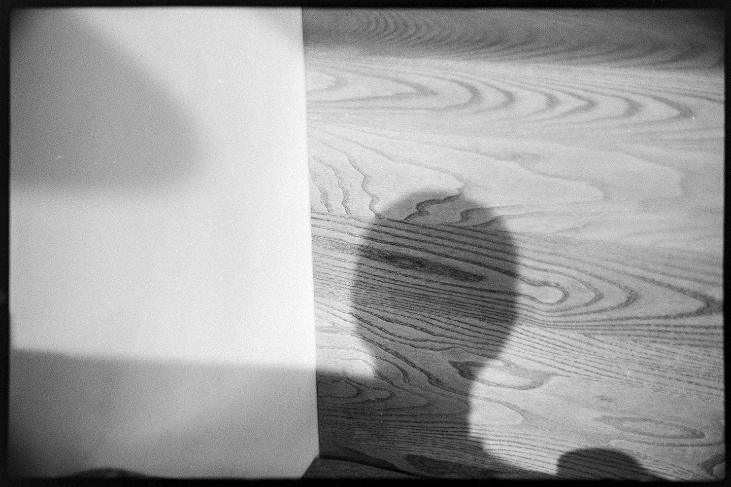 Portrait of the photographer's shadow cast on a booth in a coffee shop