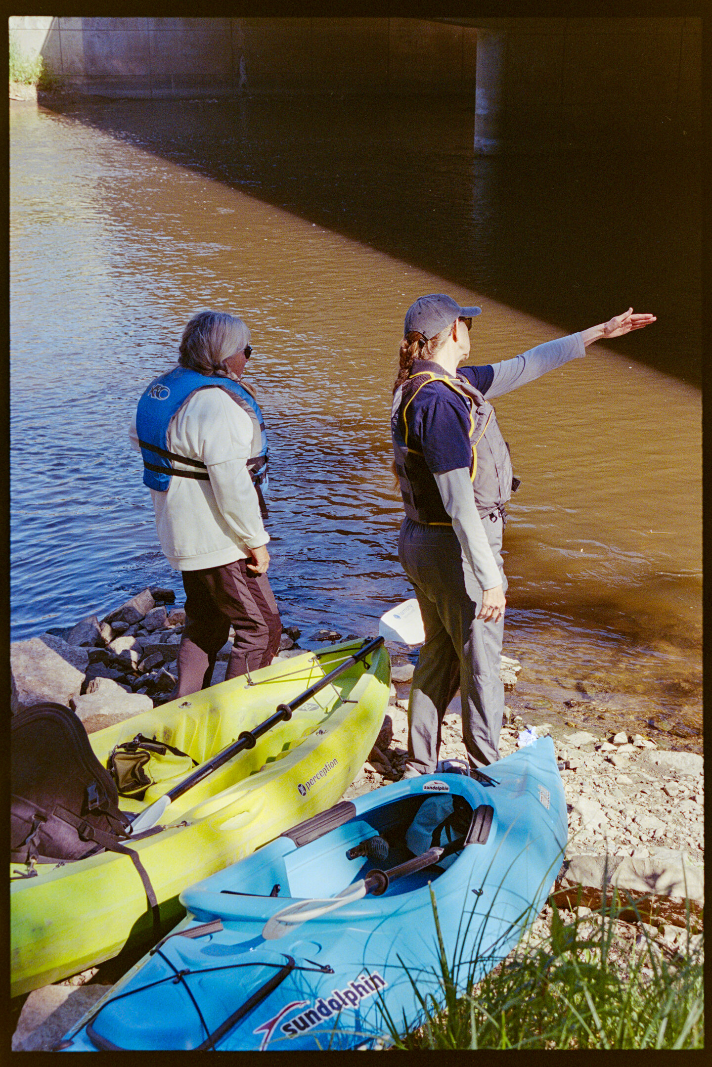 Two women prepare to launch their kayaks on the Cannon River