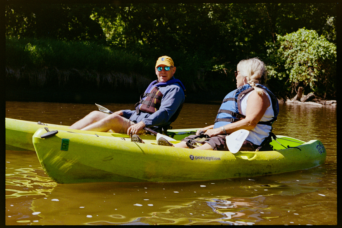 Two people kayaking next to each other down the Cannon River