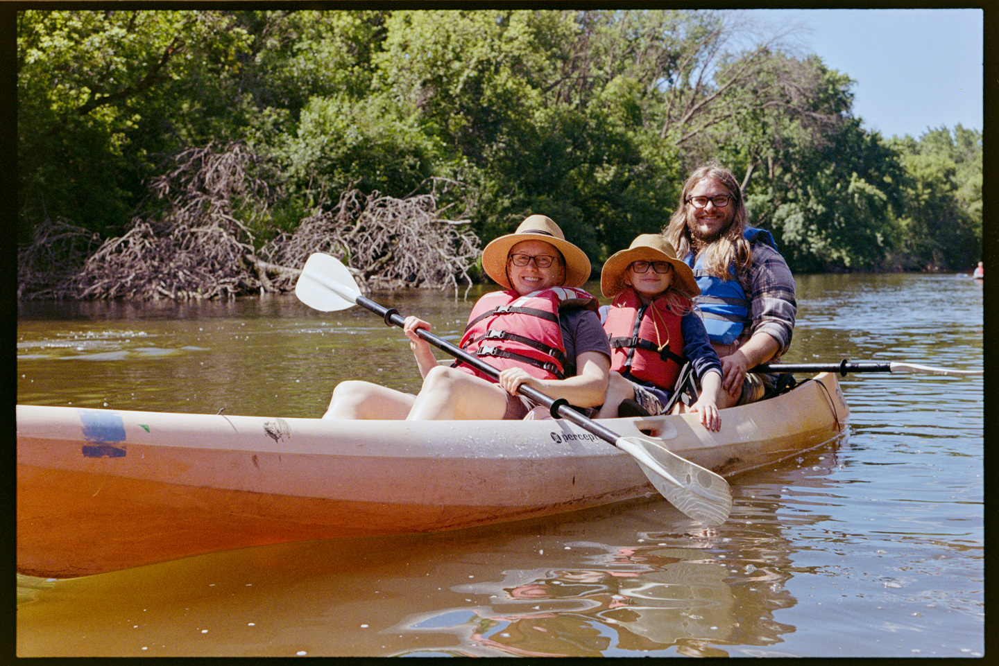 A mother, father, and young son canoeing down the Cannon River