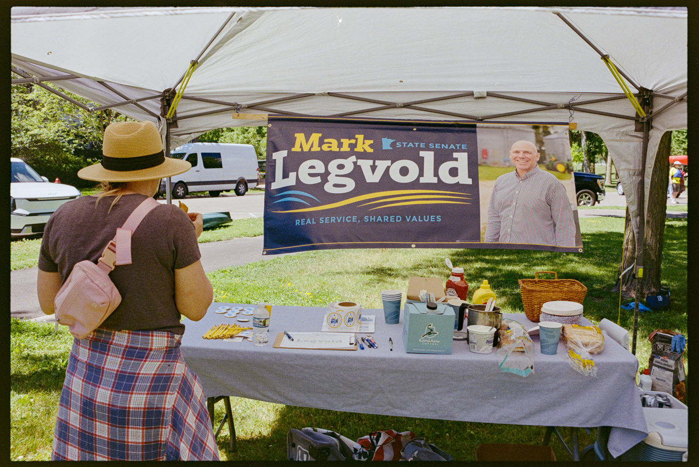 A woman looking at the Minnesota State Senate campaign table for Mark Legvold